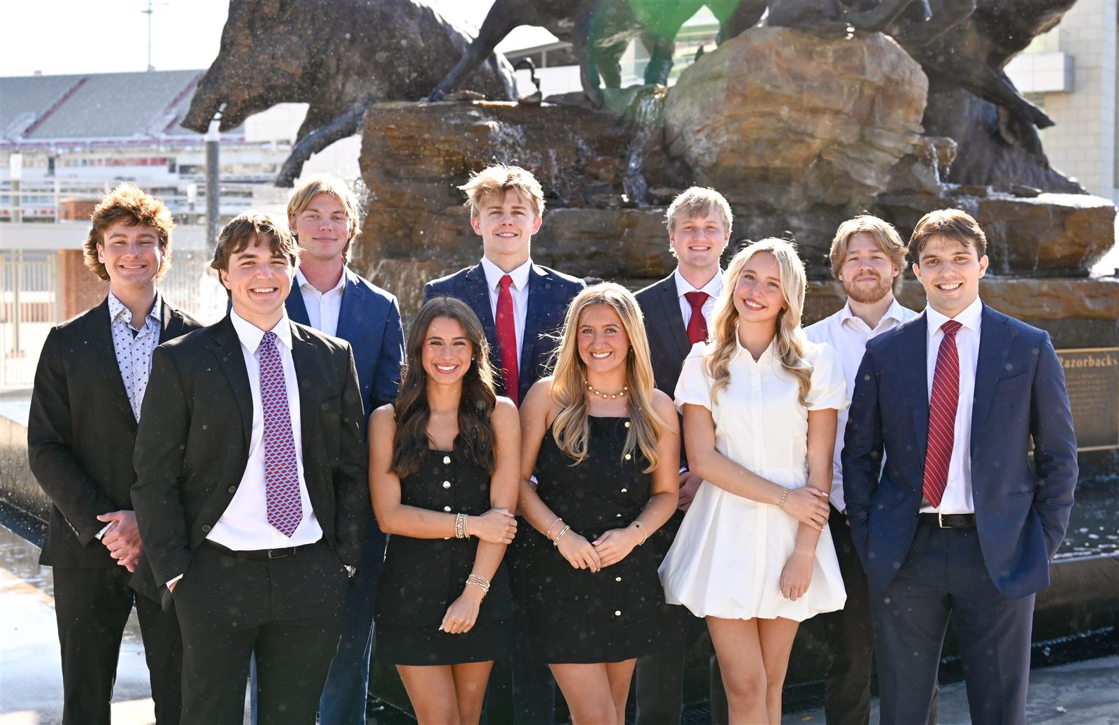 Crypto Hogs officer team standing in front of the Wild Band of Razorbacks fountain